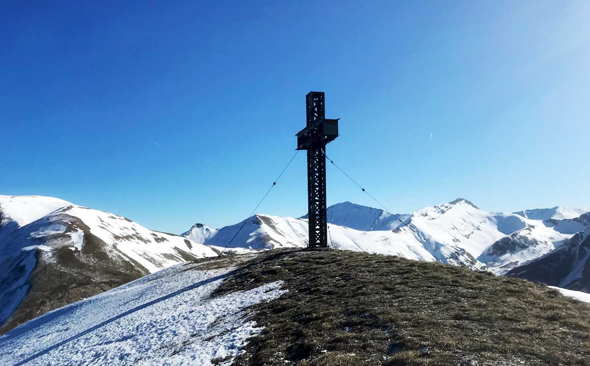 Veduta panoramica sulle cime più a nord del Parco Nazionale dei Monti Sibillini, con al centro la Croce di Monte Rotondo, ben visibile dalle vallate sottostanti.